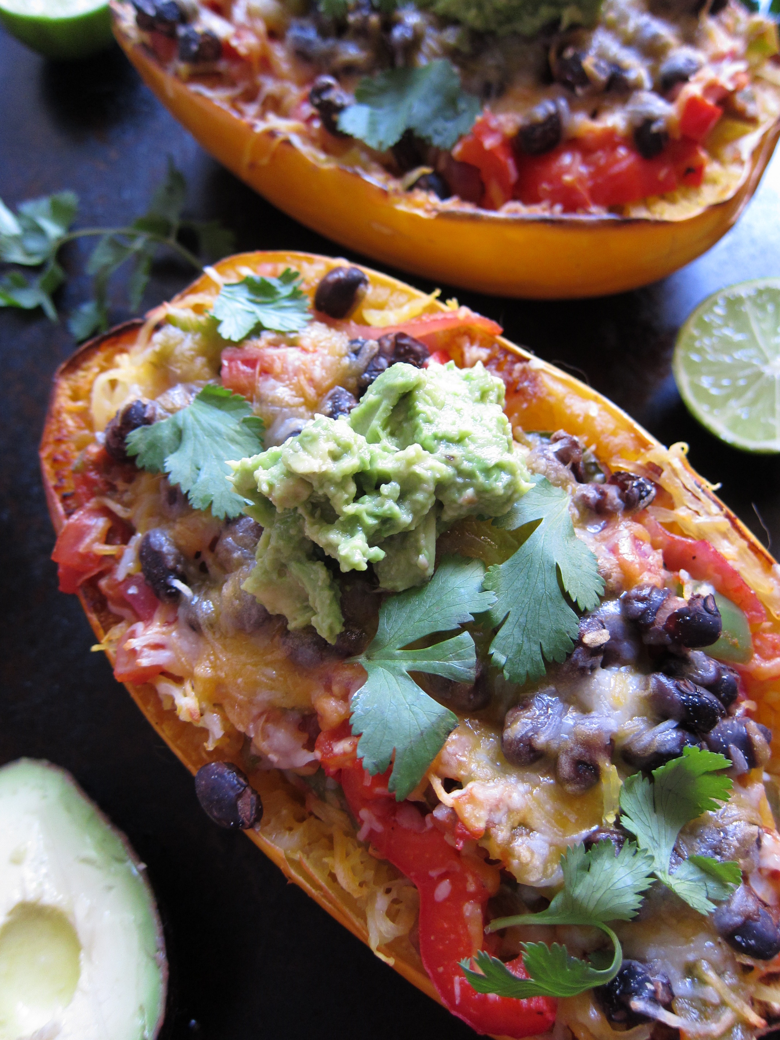 Spaghetti Squash Burrito Bowl is a meatless meal your family will love. This hearty and good-for-you meal is full of green and red peppers, onions and black beans and topped with plenty of cheese and a scoop of guacamole.